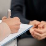 mid-shot-woman-therapist-taking-notes-in-clipboard-scaled